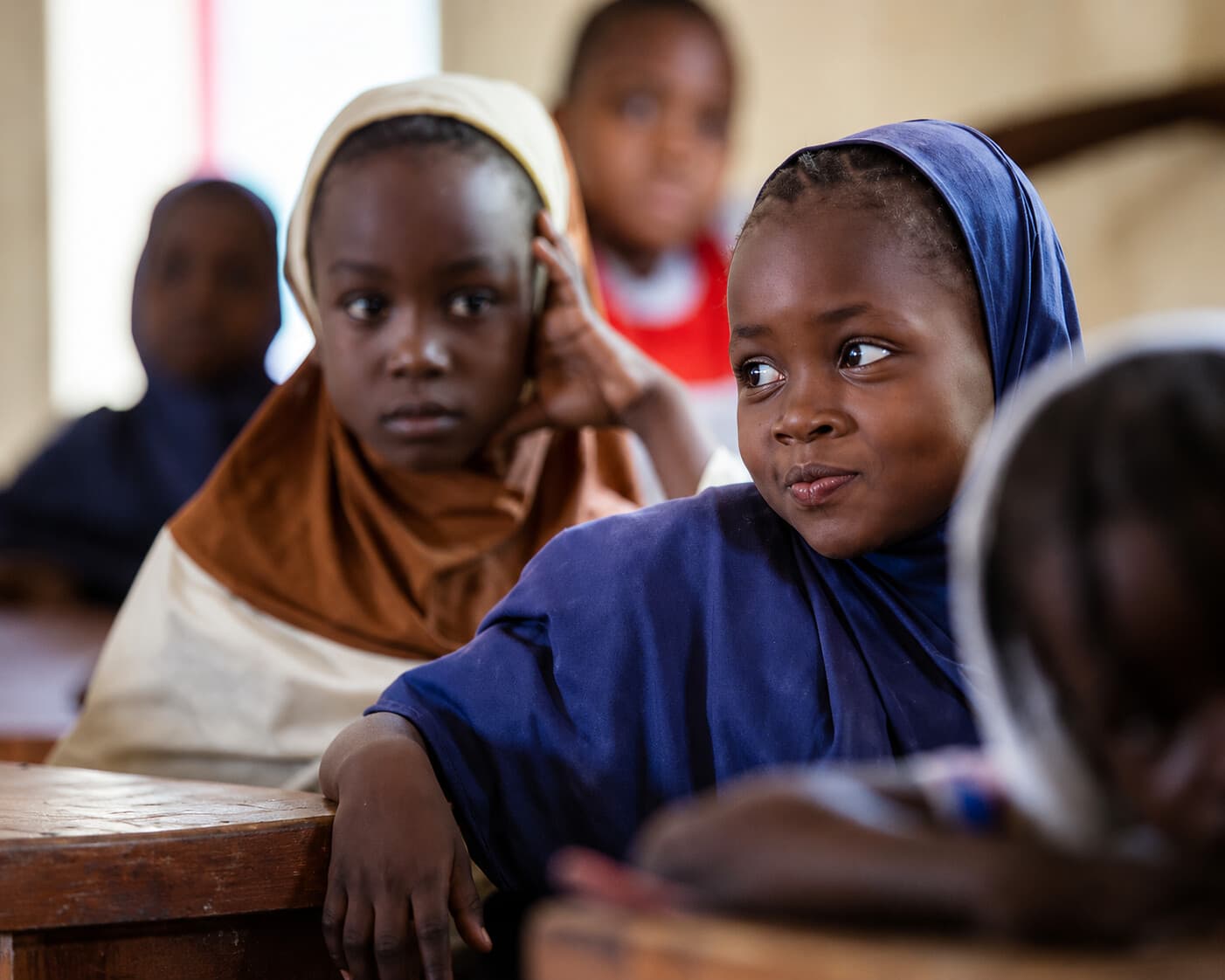 Deux jeunes filles nigériennes en hijab dans une salle de classe, regard direct et confiant